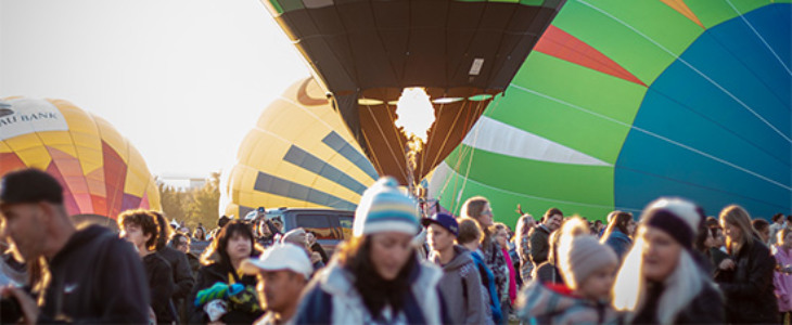 crowd of people gathered around air balloons